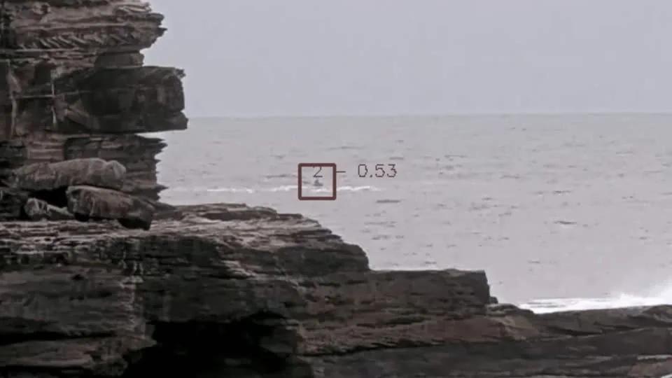 Recorded coastal footage with a detection box around a kayaker on the water.