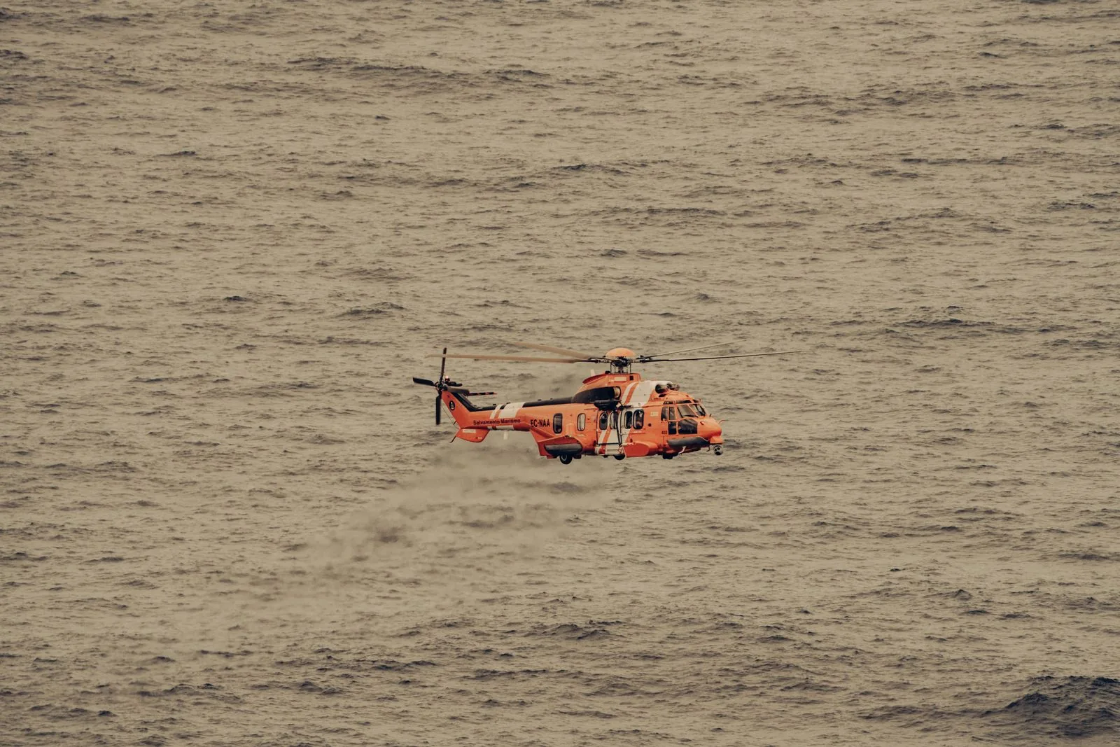 Stock photograph of a maritime rescue helicopter flying over the sea.